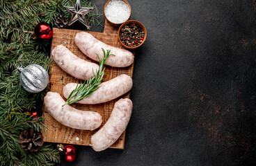 Christmas sausages with spices on a stone background with Christmas trees and Christmas decorations, gifts 
with copy space