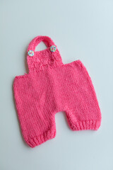 Various colors and types of cotton clothing, knitted newborn clothes and newborn hats on a white background.