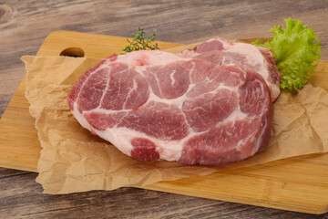 Raw pork steak over wooden board