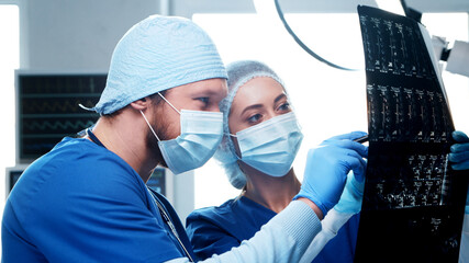 Professional medical doctors working in emergency medicine. Portrait of the surgeon and the nurse in protective masks performing surgical operation.