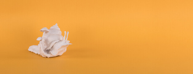 Fototapeta na wymiar white artificial decorative snail on a yellow background