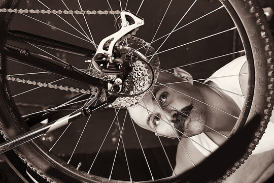 Vintage Portrait Of A Mustachioed Man Repairing A Bicycle Wheel, Eccentric Hipster