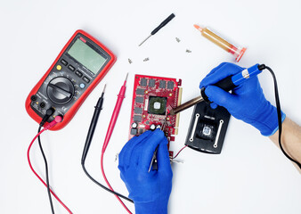Hands of computer engineer doing repair damaged graphics card on isolated background. Concept of...