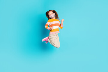 Full length photo of pretty cheerful girl jumping wear mask casual outfit isolated over bright blue...