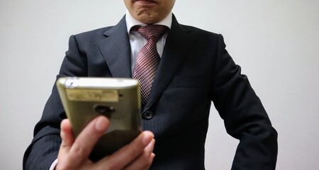スマホを見るビジネスマンのクローズアップ