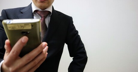 スマホを見るビジネスマンのクローズアップ