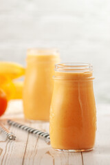 Tangerine and banana smoothie on wooden table