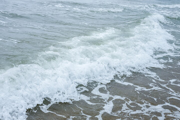 Small waves on the sea coast, foaming waves