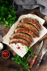 Fried sausages. Grilled sausages with spices on a wooden serving Board. Delicious meat sausages