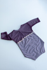 Various colors and types of cotton clothing, knitted newborn clothes and newborn hats on a white background.