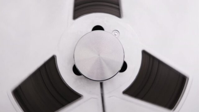 Tape reels rotating of retro tape recorder. Vintage music player close up. Spinning reels metallic color. Party. Loop. Macro. Front view. Popular Disco Trends 60s, 70s, 80s, 90s