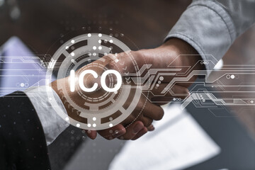 Double exposure of two businesspeople handshake and initial coin offering, ICO hologram drawing...
