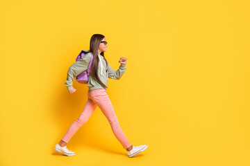 Fototapeta na wymiar Full length portrait of student walking hurry wear stylish hoodie isolated on vivid yellow color background
