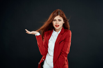 Pretty woman with long hair red jacket makeup lips charm dark background