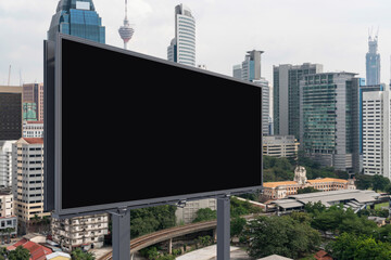 Blank black road billboard with Kuala Lumpur cityscape background at day time. Street advertising poster, mock up, 3D rendering. Side view. The concept of marketing communication.