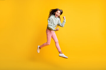 Fototapeta na wymiar Full length photo of little people jump hand fist up yes achievement trendy hoodie isolated on yellow color background