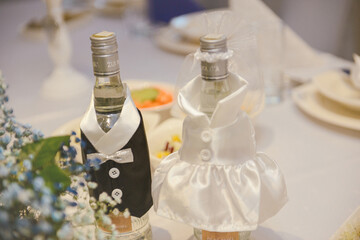 Bottle of cold vodka and wine bottle in bucket with ice and orange juice in jug on table, copy space. Alcohol bottles in ice bucket in restaurant. Wedding party.