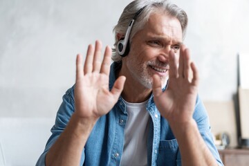 Head shot man sit on sofa in living room makes video call looks at camera, conversation by distant videocall, distance hiring job interview process, tutor and trainee study on-line concept