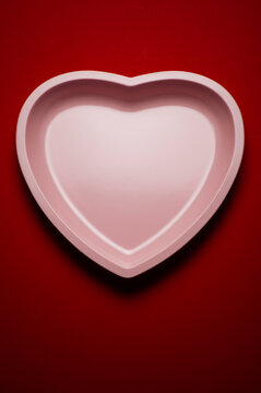 Studio Photo Of Heart Shaped Plate On Deep Red Background.