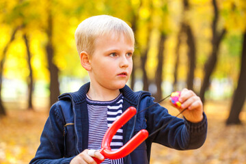 Blonde little boy in autumn park