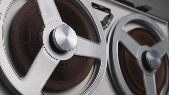 Tape reels rotating of retro tape recorder. Vintage music player close up. Spinning reels metallic color. Party. Loop. Macro. View from above. Popular Disco Trends 60s, 70s, 80s, 90s