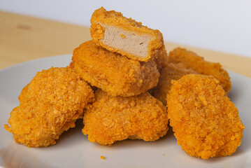 Chicken nuggets on a white plate, with ketchup