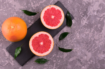 Grapefruit and grapefruit wedges on a gray background.
Flat lay. Copy space.