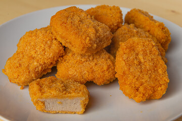 Chicken nuggets on a white plate, with ketchup