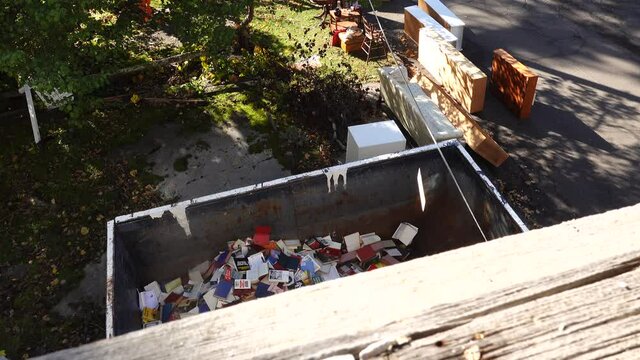 West Cornwall, Ct. USA A dumpster filled with discarded books at an old bookstore going out of business.