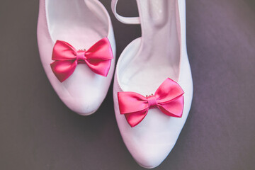 The bride shows white wedding shoes. Wedding detail. Close up.