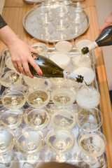 Bottle of cold vodka and wine bottle in bucket with ice and orange juice in jug on table, copy space. Alcohol bottles in ice bucket in restaurant. Wedding party.