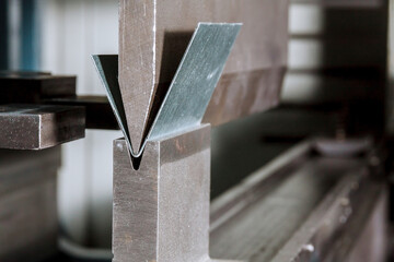 Bending sheet metal on a hydraulic machine at the factory. Bend tools, press brake punch and die....