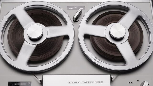 Tape reels rotating of retro tape recorder. Vintage music player close up. Spinning reels metallic color. Party. Loop. Macro. Front view. Popular Disco Trends 60s, 70s, 80s, 90s