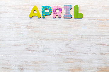 Word of calendar with month April on wood background