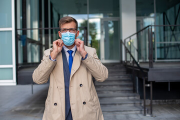 Businessman leaves the office with a face mask protect from Coronavirus.