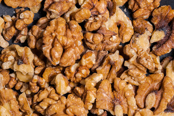 Close up of walnuts in dark grey cast iron pan for roasting spices