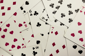 Many playing cards of different colors and suits are scattered throughout the frame.