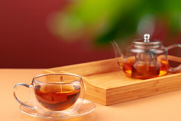 Glass teapot and cup with black tea