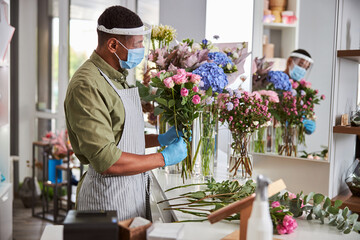 Young handsome man working in flower shop