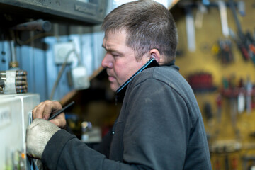 Close-up portrait of a man in the workplace with a mobile phone