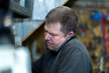 Close-up portrait of a man in the workplace with a mobile phone