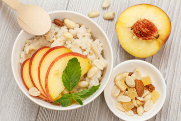 Sorghum salad with nuts and fresh peach on gray boards.