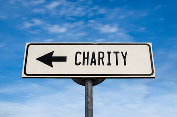 Charity road sign, arrow on blue sky background. One way blank road sign with copy space. Arrow on a pole pointing in one direction.