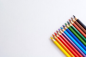 Naklejka premium Bright colored pencils for drawing on a white isolated background with an empty space for a signature. Pastel colors of new pencils.