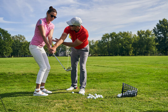 Instructor teaching his client a golf technique