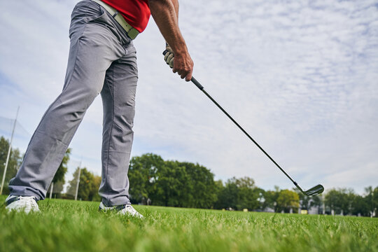 Sportsman with a golf club training outdoors