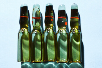 glass ampoules with liquid medicine in blue light