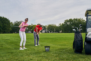 Beginner golfer and her coach training together