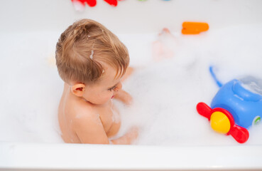 baby in bathtub with foam