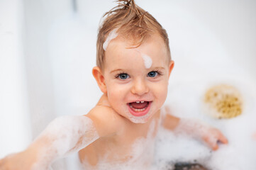 baby in bathtub with foam